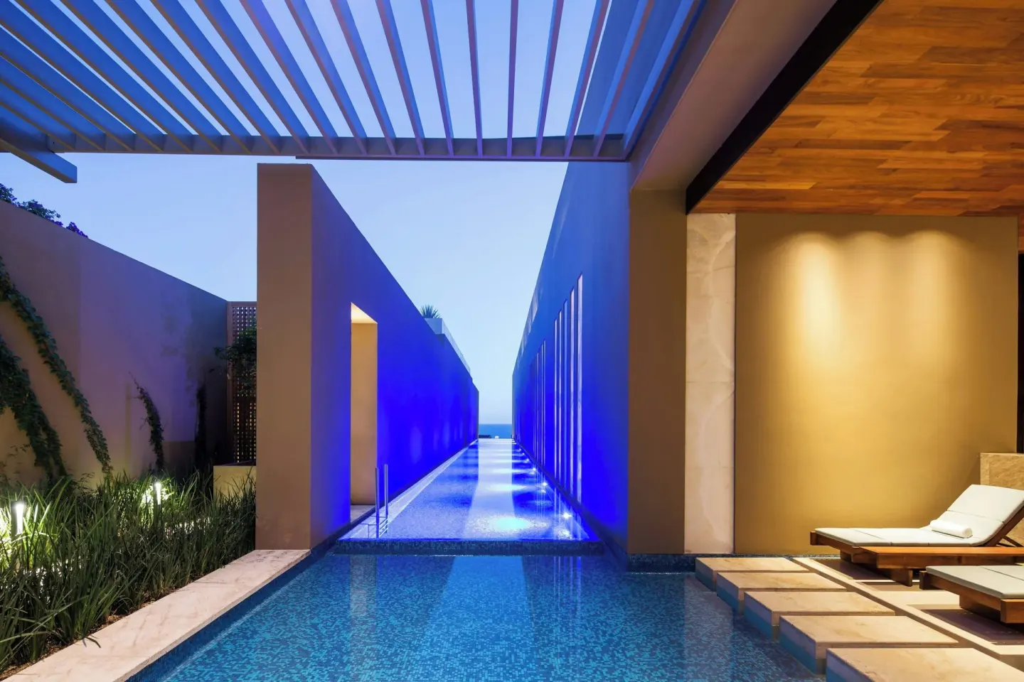 Blue-lit spa water corridor and lounge chairs at JW Marriott Los Cabos Beach Resort & Spa.