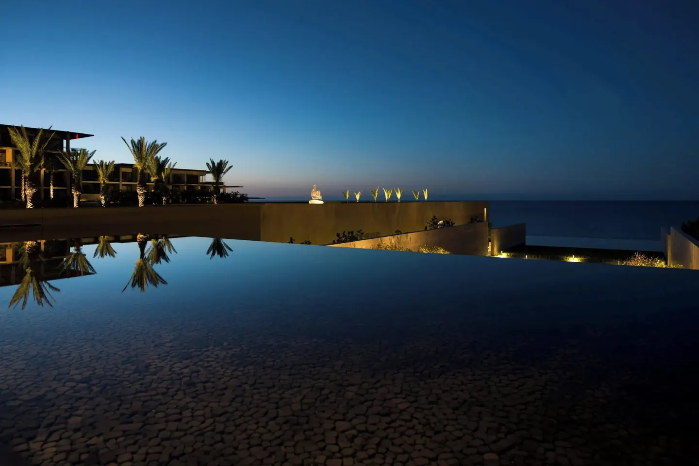 Infinity pool at dusk overlooking the sea at JW Marriott Los Cabos Beach Resort & Spa.