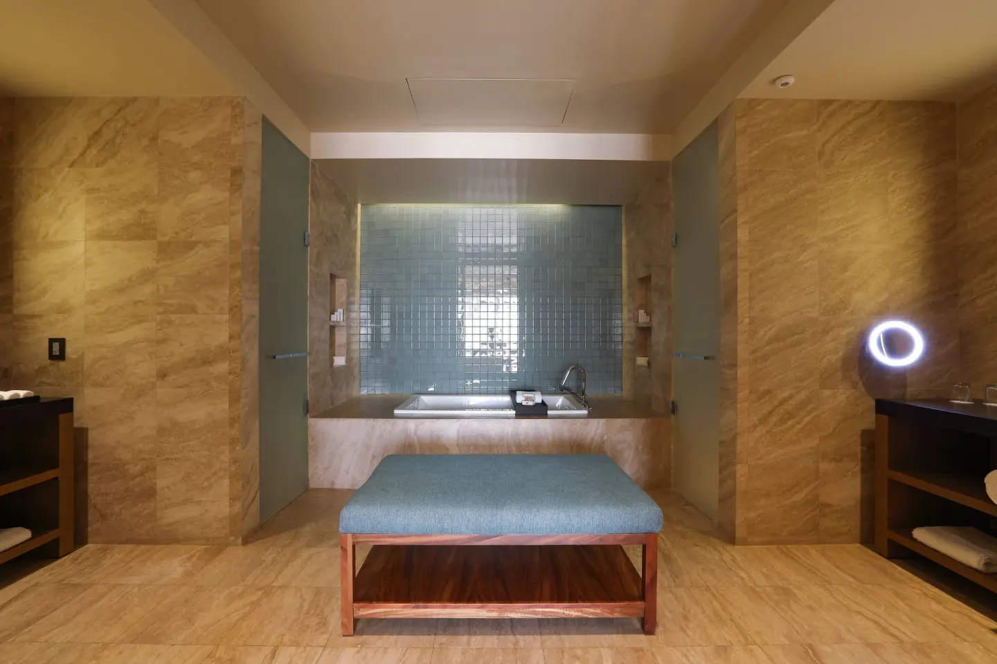 Stone bathroom with tub, bench and vanity areas at JW Marriott Los Cabos Beach Resort & Spa.