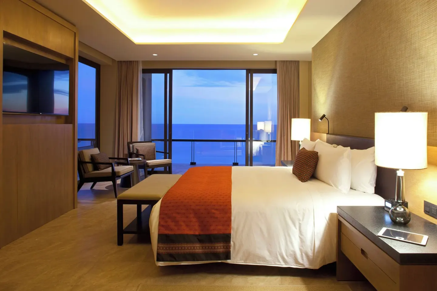 Ocean-view king bed guest room at dusk at JW Marriott Los Cabos Beach Resort & Spa.