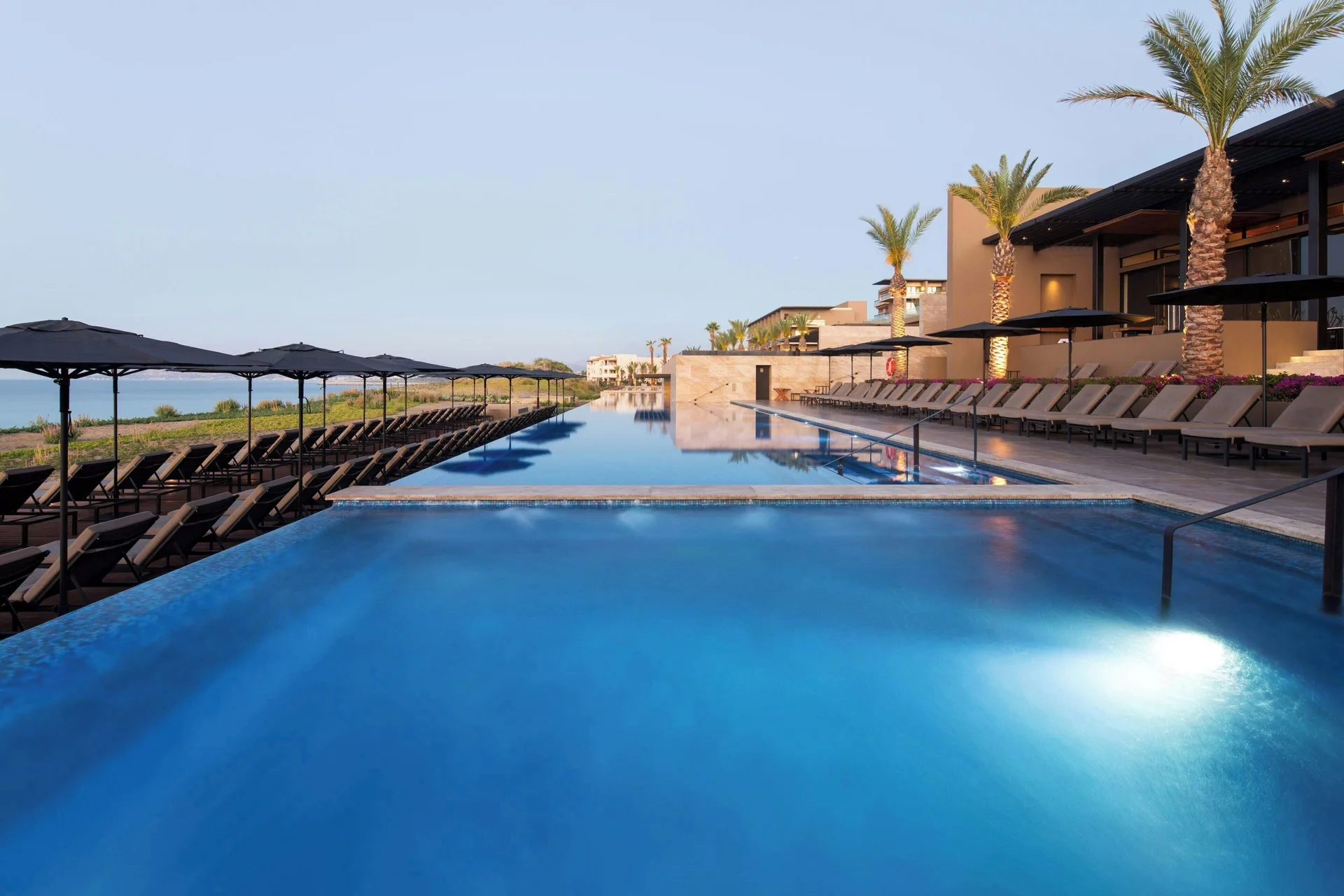 Tiered outdoor pools and shaded loungers at JW Marriott Los Cabos Beach Resort & Spa.
