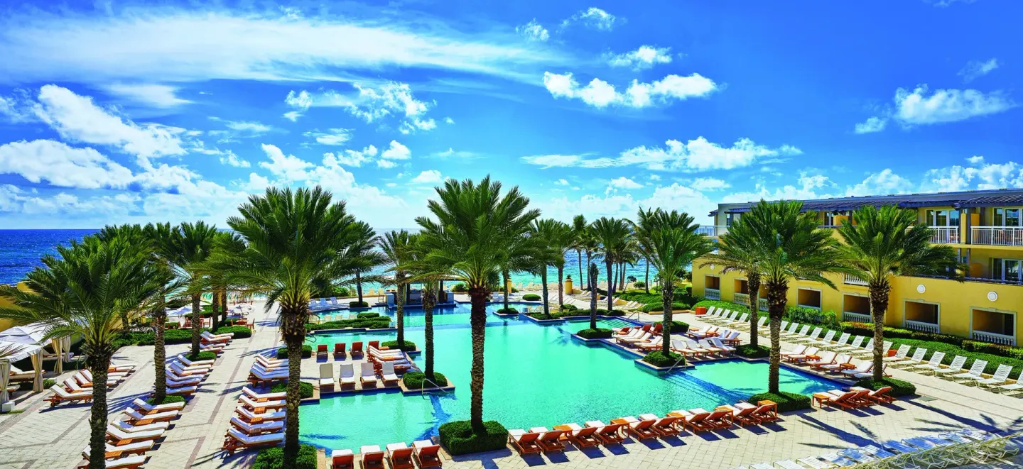 Palm-lined resort pool and ocean at JW Marriott St. Maarten Beach Resort & Spa.