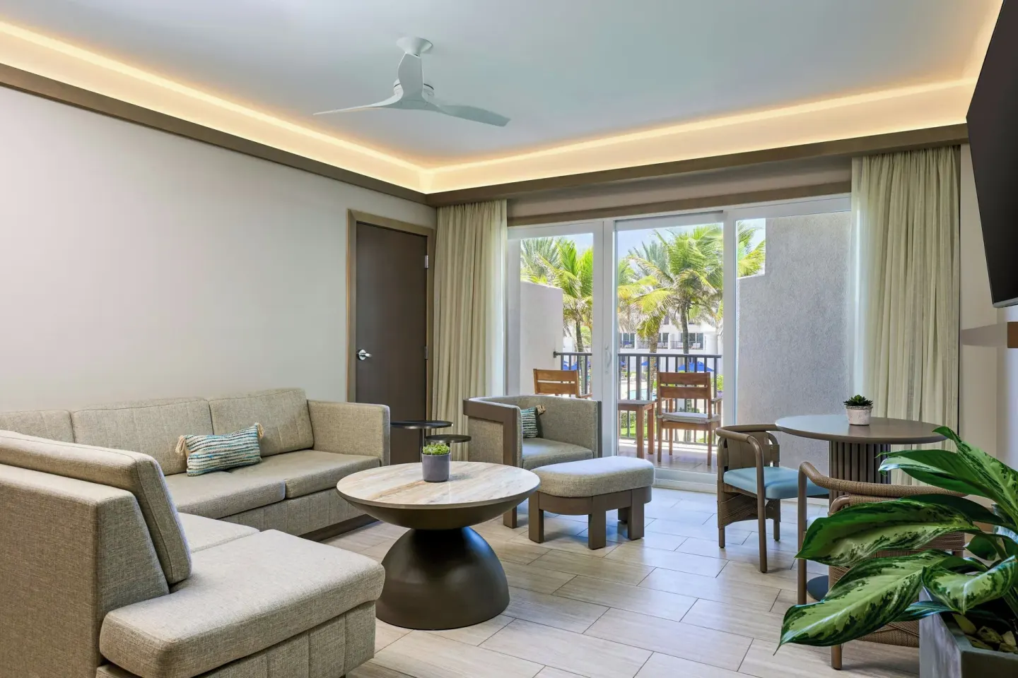 Resort living area with sofa and balcony at JW Marriott St. Maarten Beach Resort & Spa.