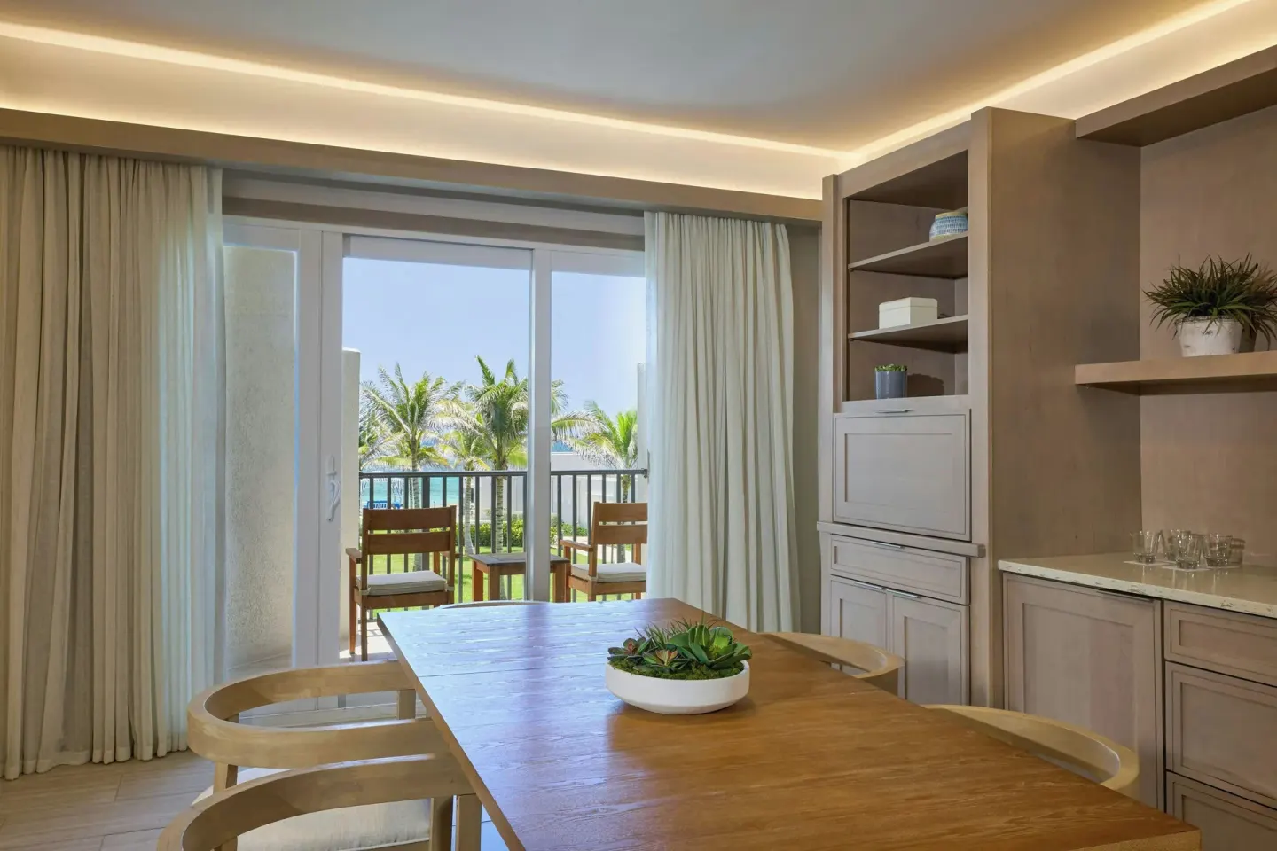 Suite dining table beside sliding doors to a palm-view balcony at JW Marriott St. Maarten Beach Resort & Spa.