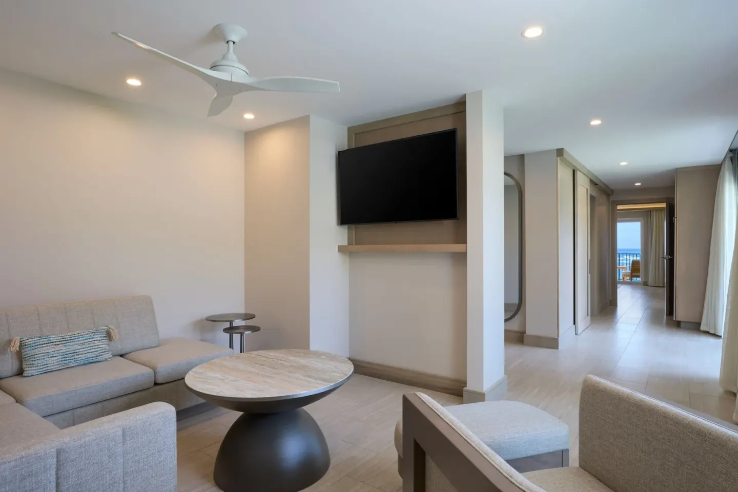 Suite living area with sofa, TV, and distant balcony view at JW Marriott St. Maarten Beach Resort & Spa.