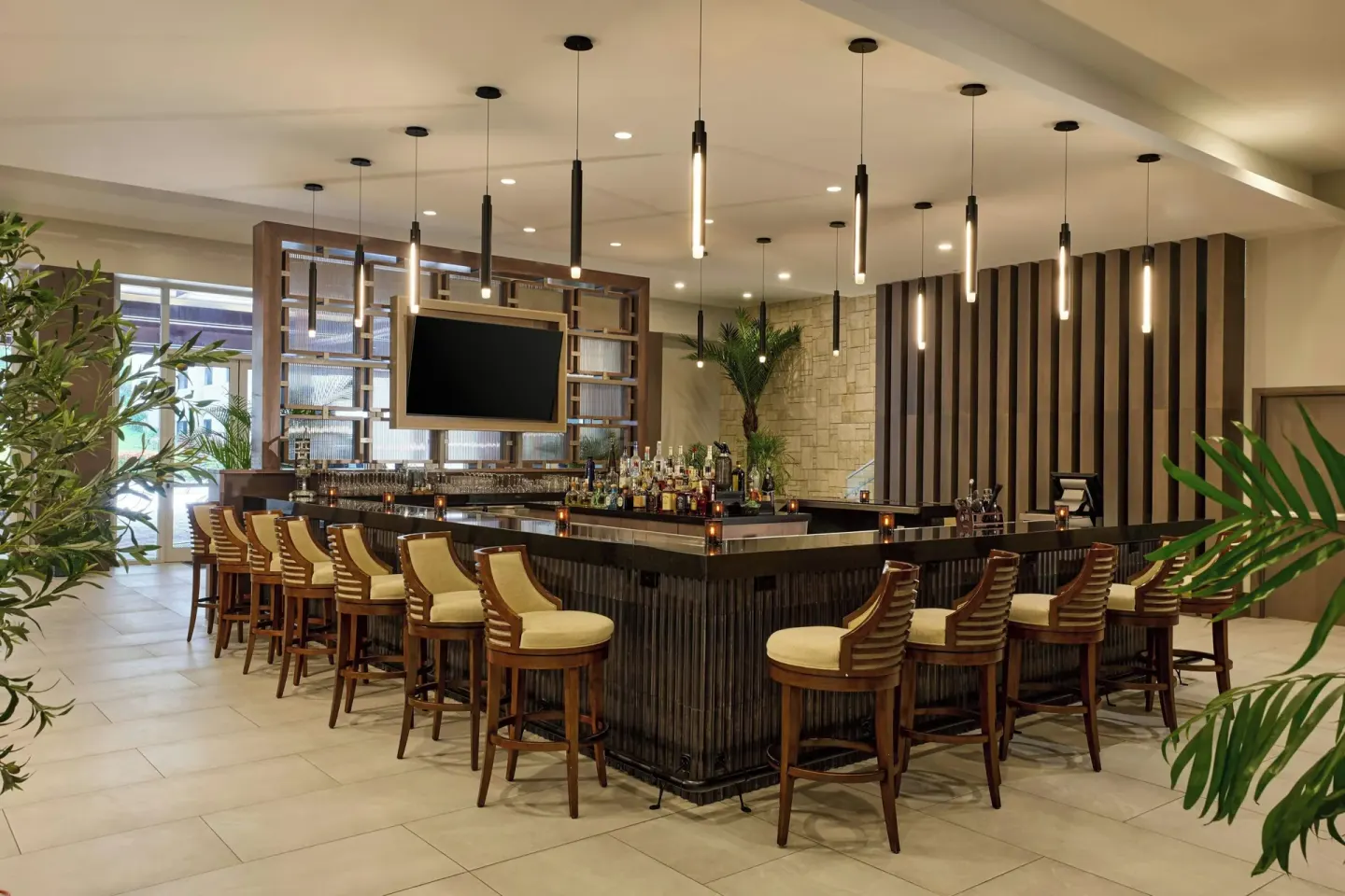 Lobby bar with wood stools and pendant lights at JW Marriott St. Maarten Beach Resort & Spa.
