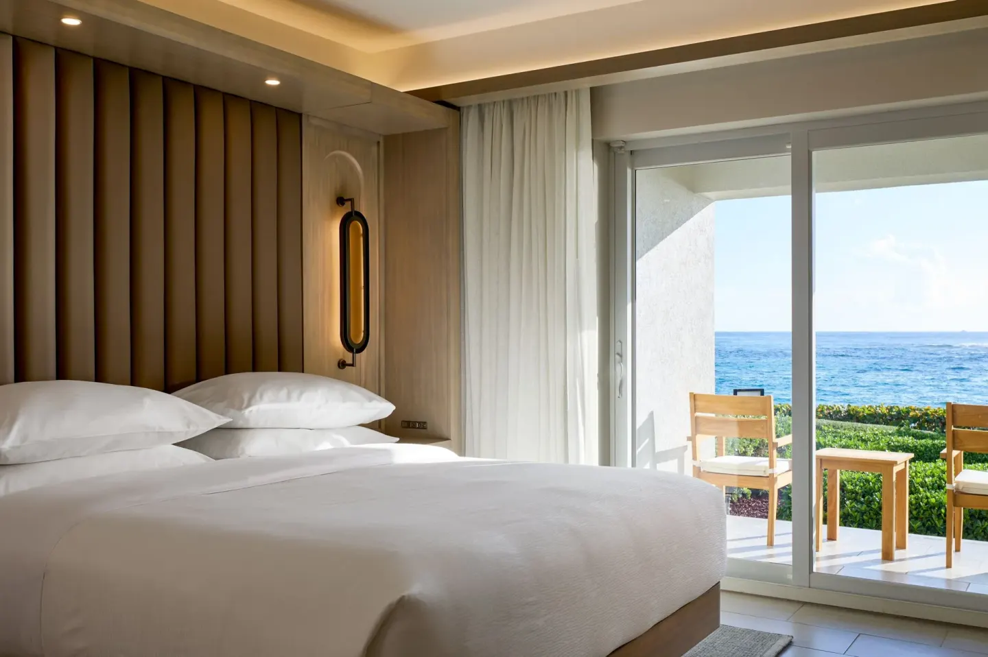 Oceanfront deluxe room bed and balcony at JW Marriott St. Maarten Beach Resort & Spa.