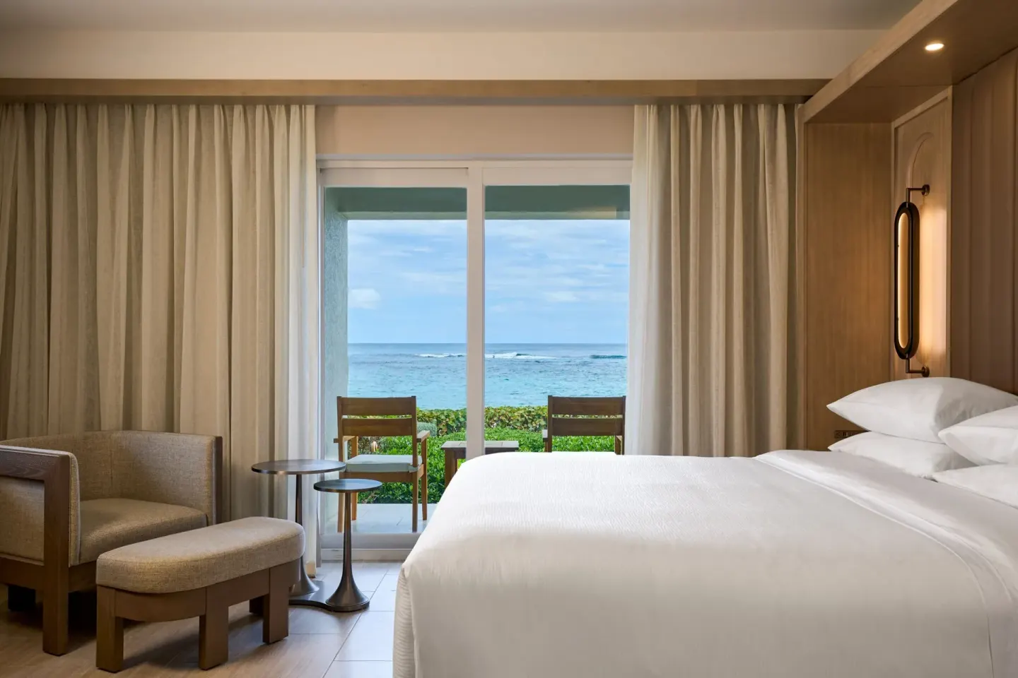 Ocean-view deluxe room balcony and king bed at JW Marriott St. Maarten Beach Resort & Spa.