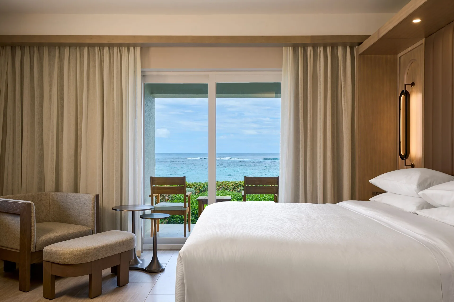 Ocean-view deluxe room balcony and king bed at JW Marriott St. Maarten Beach Resort & Spa.