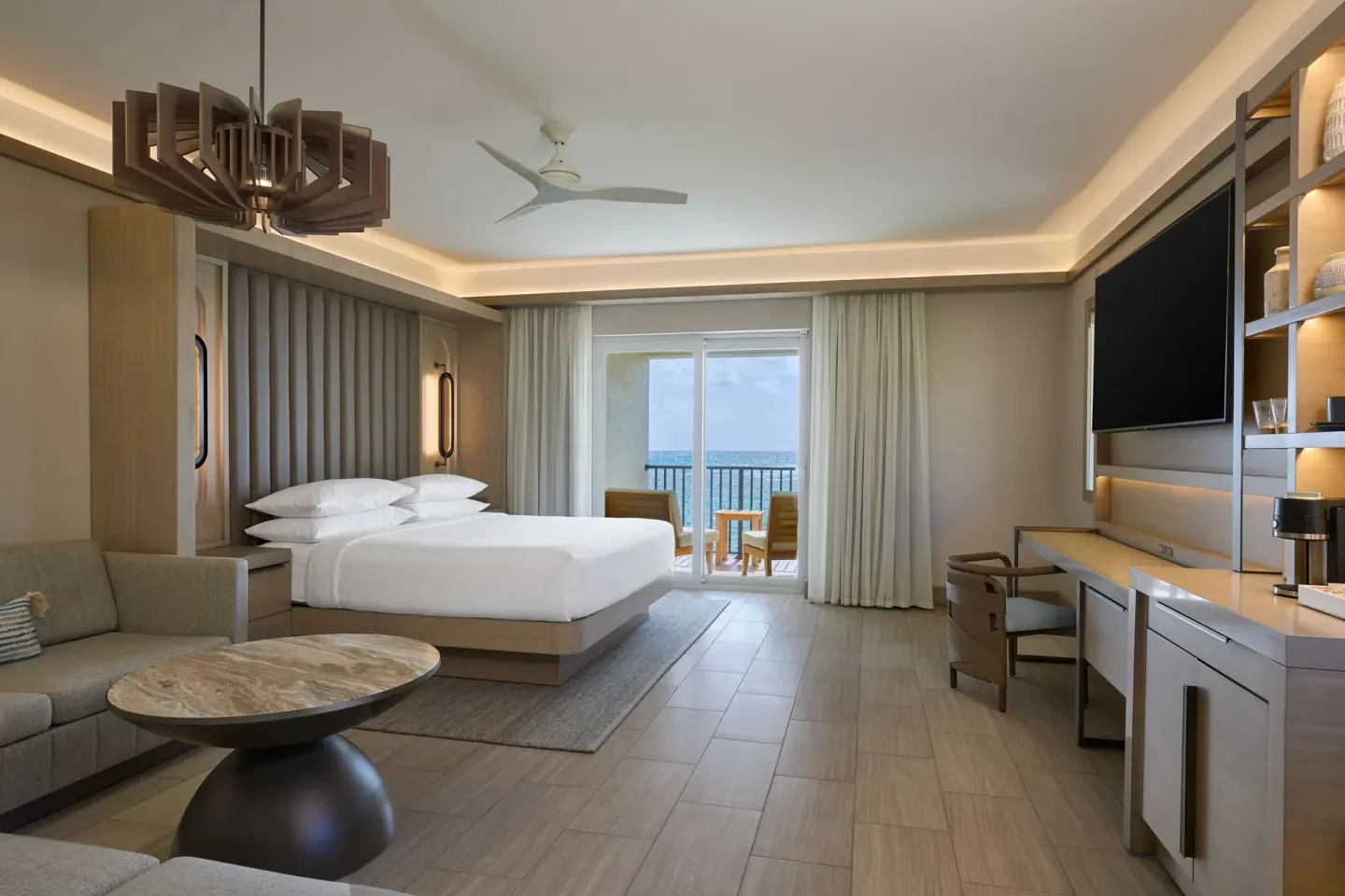 Deluxe king room with sofa bed, desk, and ocean balcony at JW Marriott St. Maarten Beach Resort & Spa.