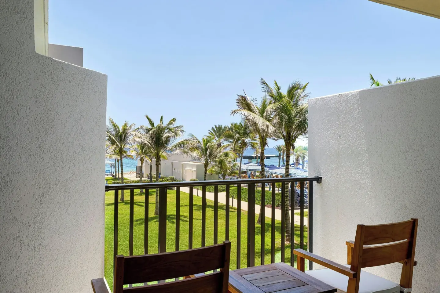 Deluxe room balcony with chairs and resort grounds at JW Marriott St. Maarten Beach Resort & Spa.