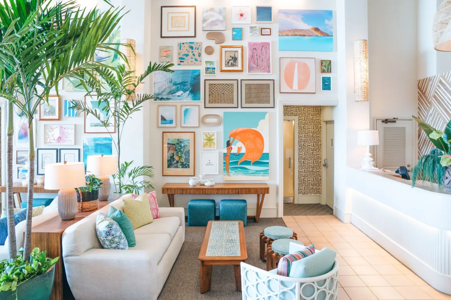 Colorful lobby seating and gallery wall with palms at Kaimana Beach Hotel.