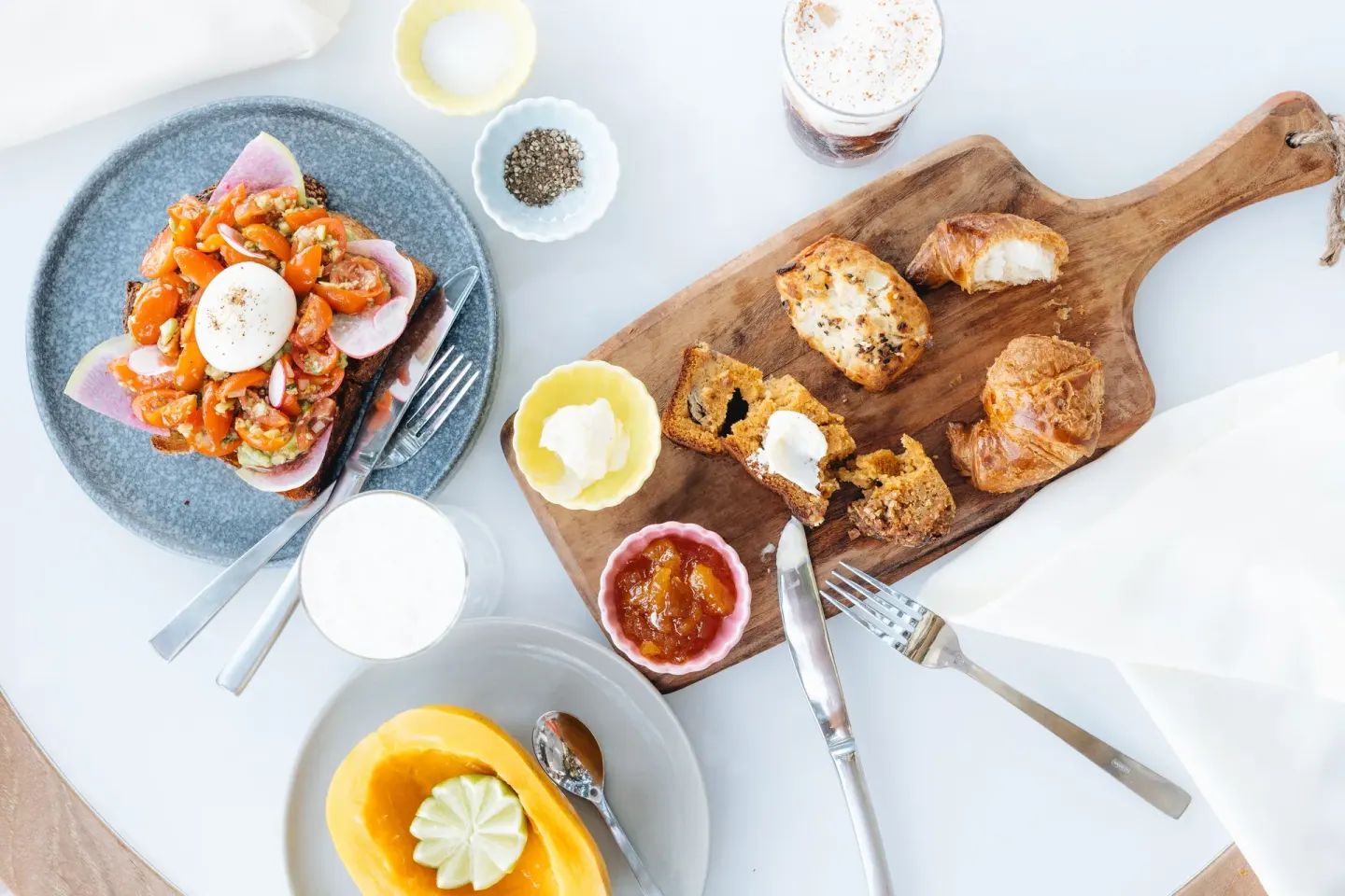 A breakfast spread with toast, pastries, fruit, and drinks is set at Kaimana Beach Hotel.