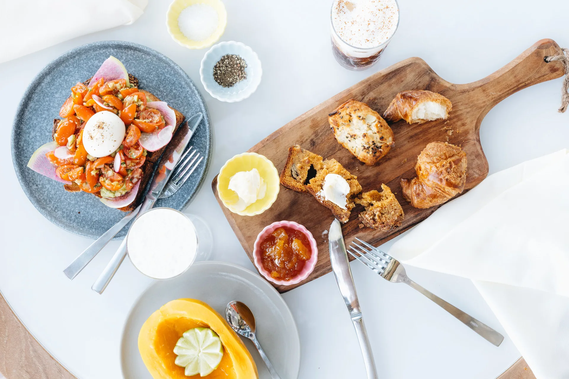 A breakfast spread with toast, pastries, fruit, and drinks is set at Kaimana Beach Hotel.