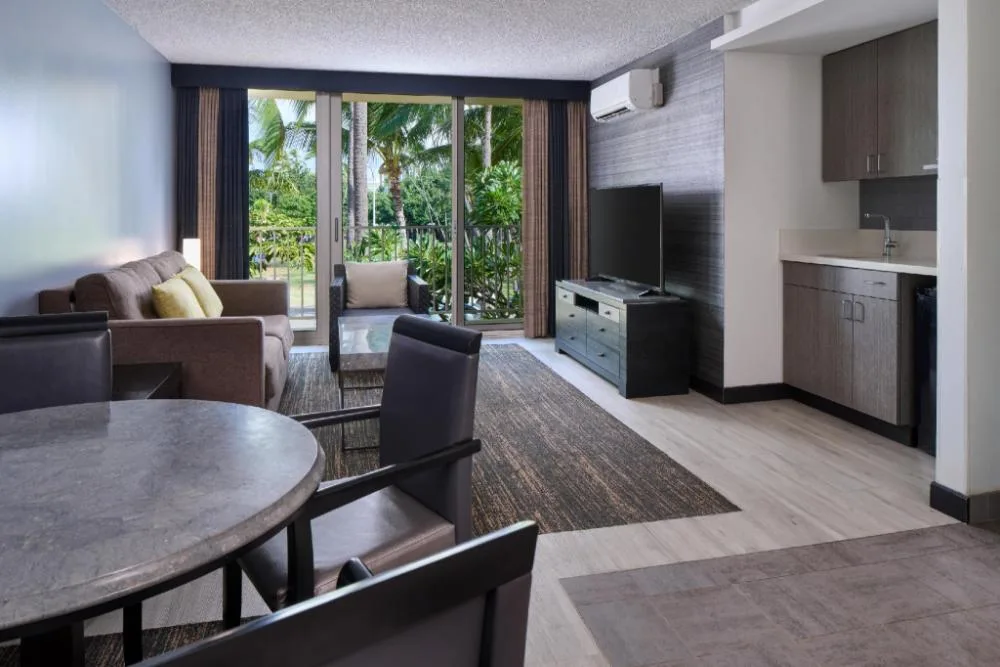 Classic 1-Bedroom Suite living area with kitchenette and lanai at Kaimana Beach Hotel.