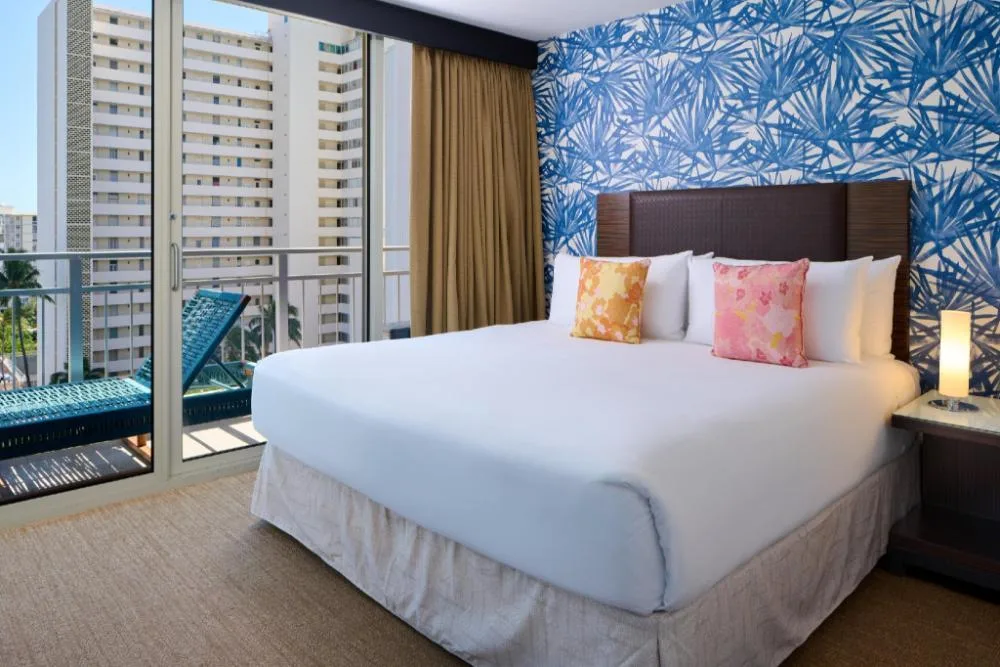Diamond Head View Junior Suite king bed and balcony at Kaimana Beach Hotel.