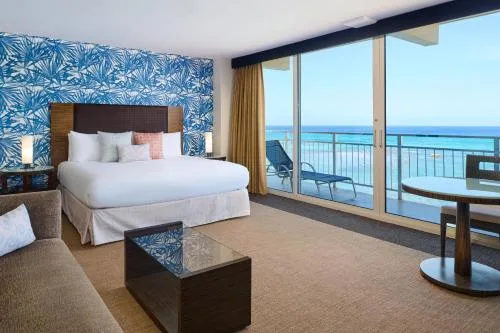 Oceanfront View Junior Suite with king bed and balcony at Kaimana Beach Hotel.