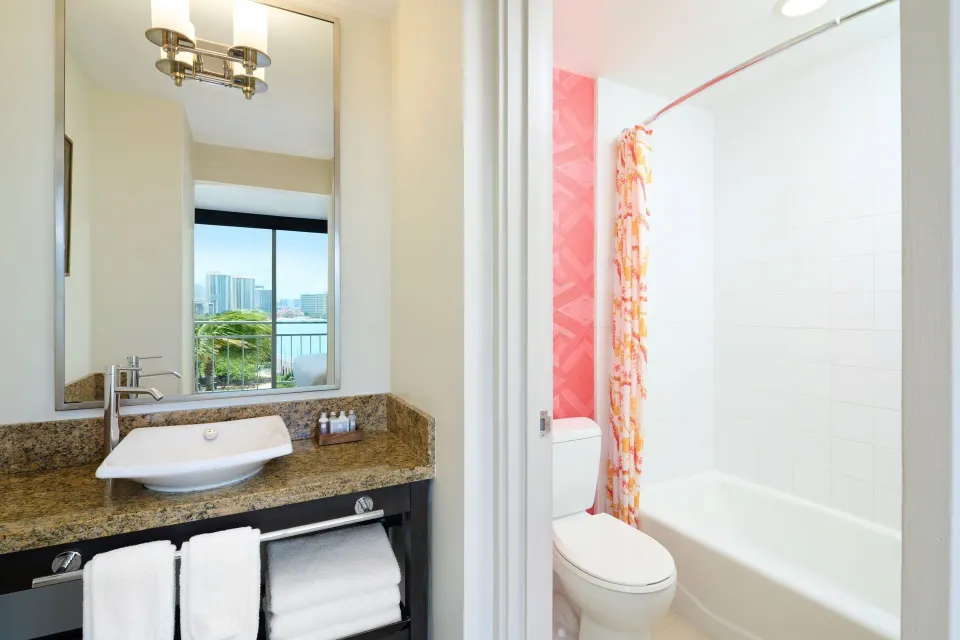 Ocean View room bathroom vanity and tub with room view reflected at Kaimana Beach Hotel.