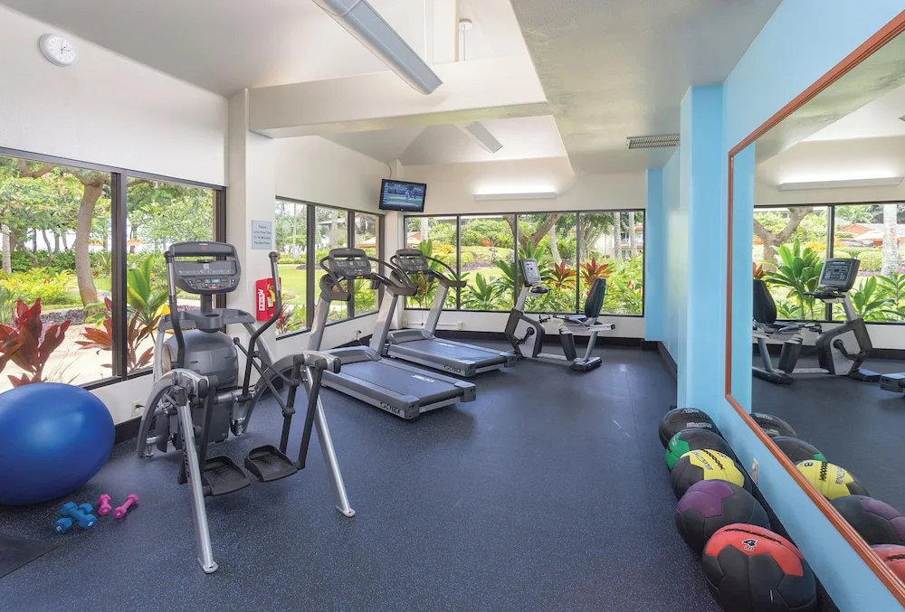 Fitness room with cardio machines and weights at Kauai Coast at the Beachboy.