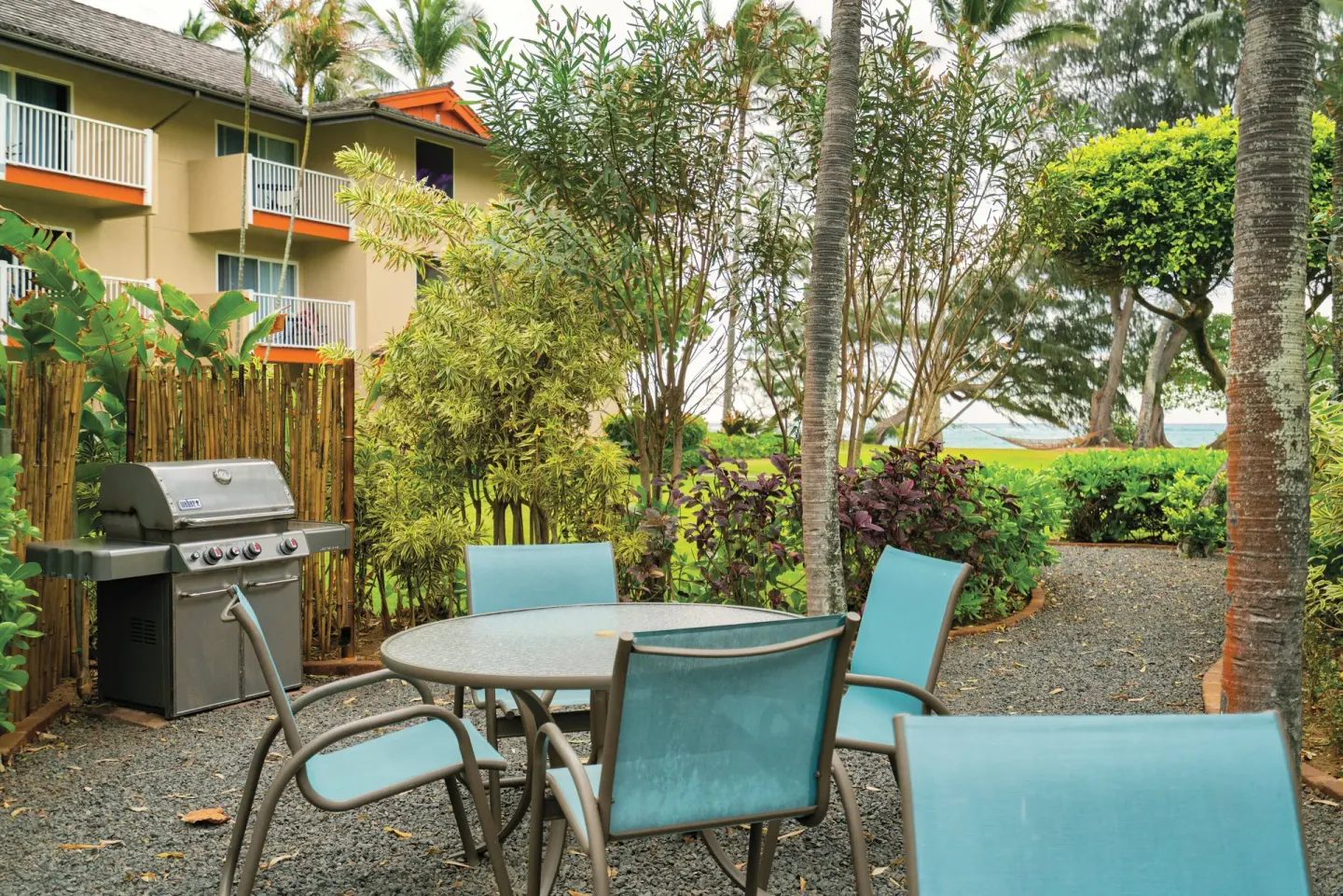 Garden patio with table, chairs, and barbecue at Kauai Coast at the Beachboy.