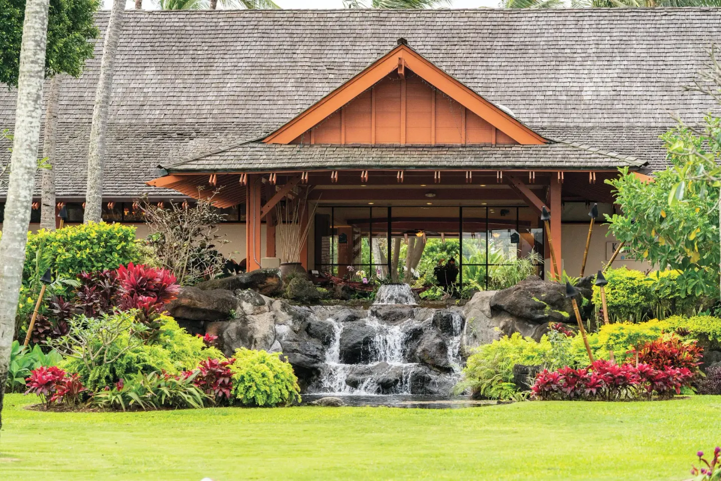 Rock waterfall and lodge-style building at Kauai Coast at the Beachboy.