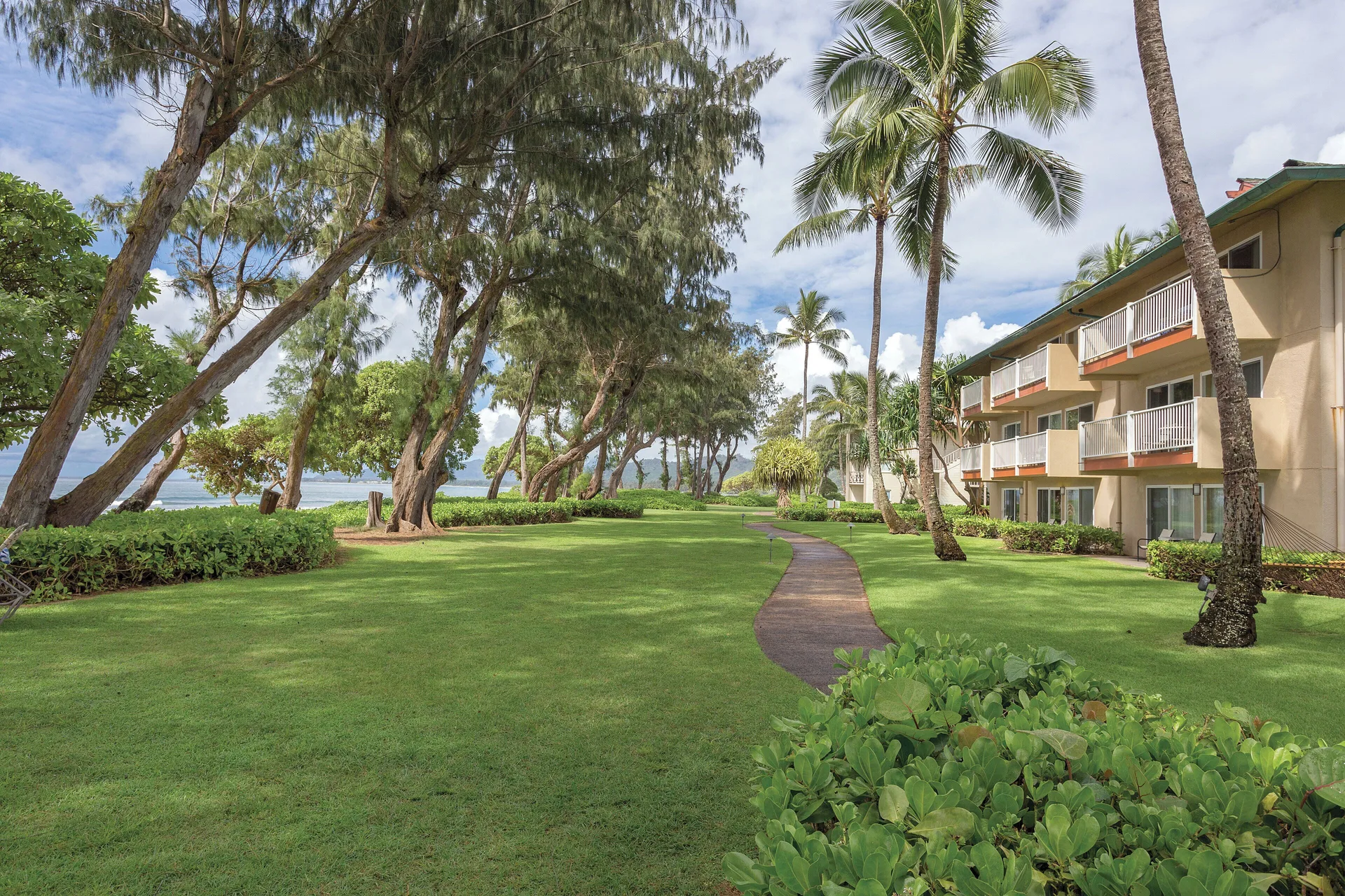 Oceanfront lawn, walkway, and balconies at Kauai Coast at the Beachboy.
