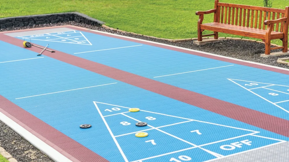 Shuffleboard court with discs and cues beside a wooden bench at Kauai Coast at the Beachboy.