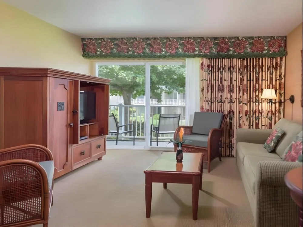 Suite Garden View living room with sofa and balcony at Kauai Coast at the Beachboy.