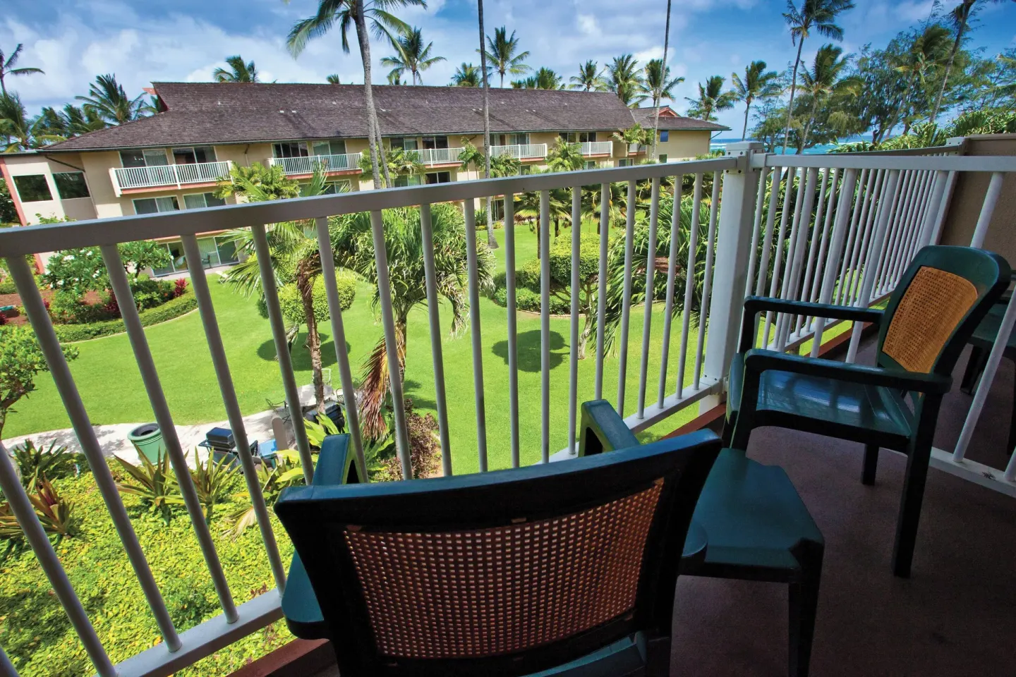 Garden view villa balcony with chairs and landscaped grounds at Kauai Coast at the Beachboy.