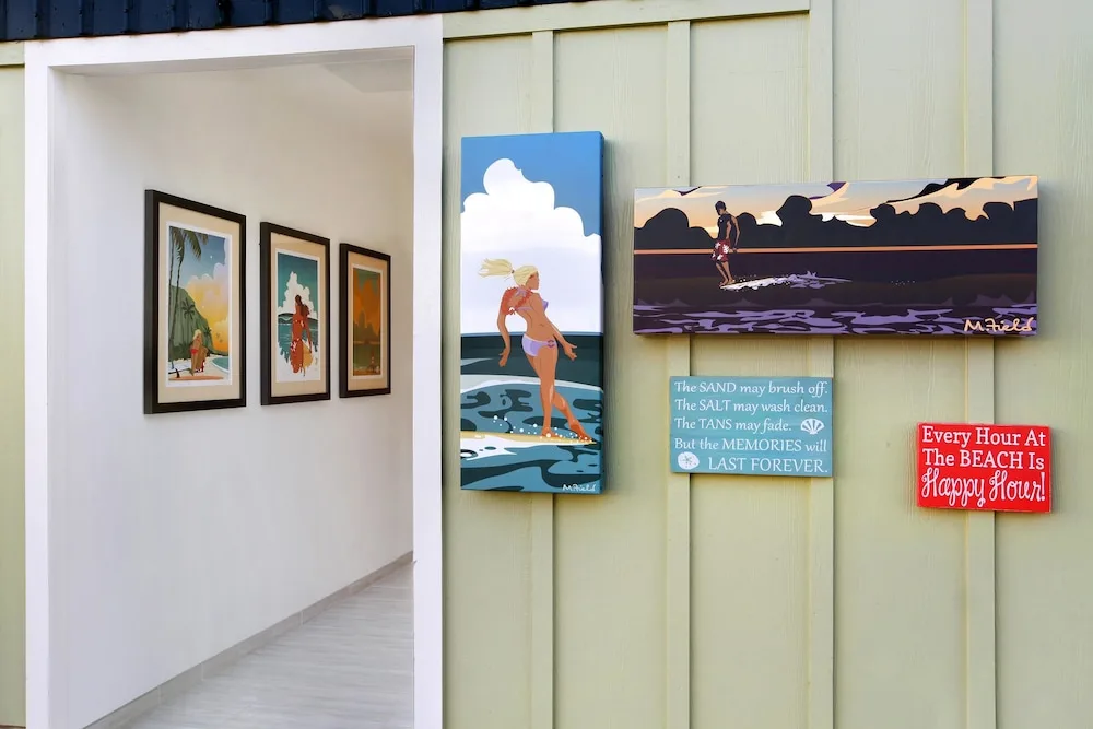 Beach-themed wall art and framed prints in a hallway at Kauai Shores Hotel.