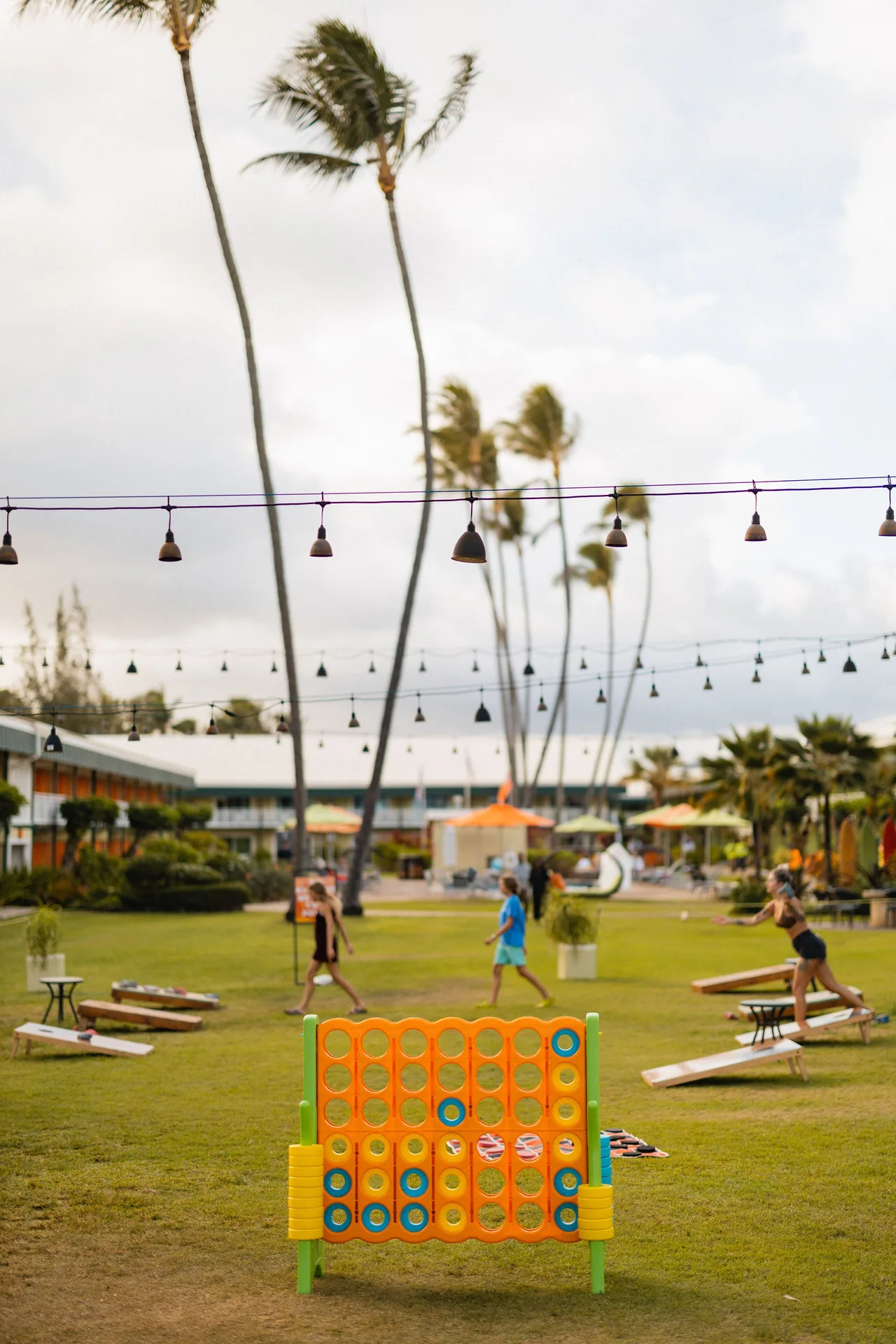 Lawn games under string lights on the grounds at Kauai Shores Hotel.