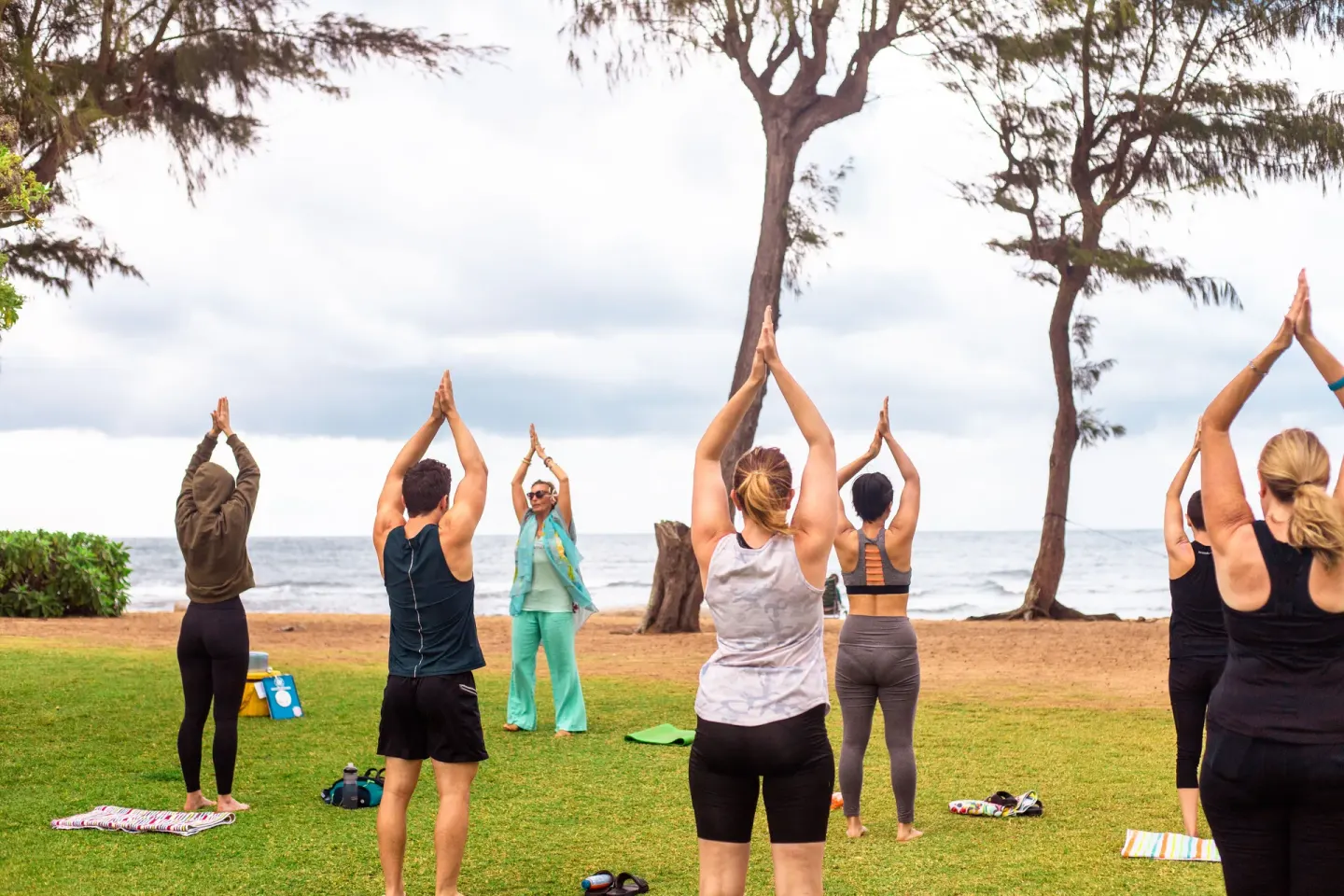 Guests practice yoga on the oceanfront lawn at Kauai Shores Hotel.