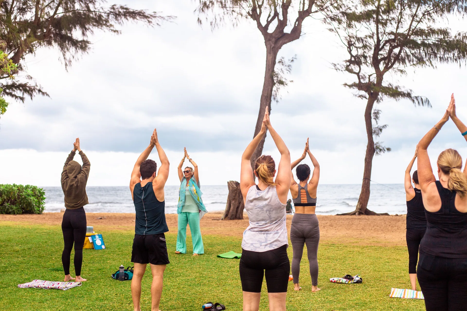 Guests practice yoga on the oceanfront lawn at Kauai Shores Hotel.