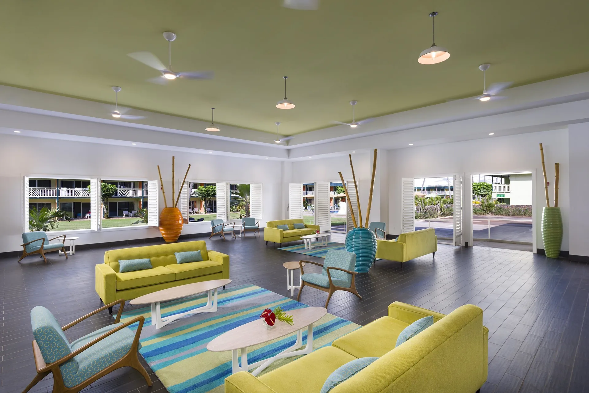 Open lobby seating area with large windows and colorful sofas at Kauai Shores Hotel.
