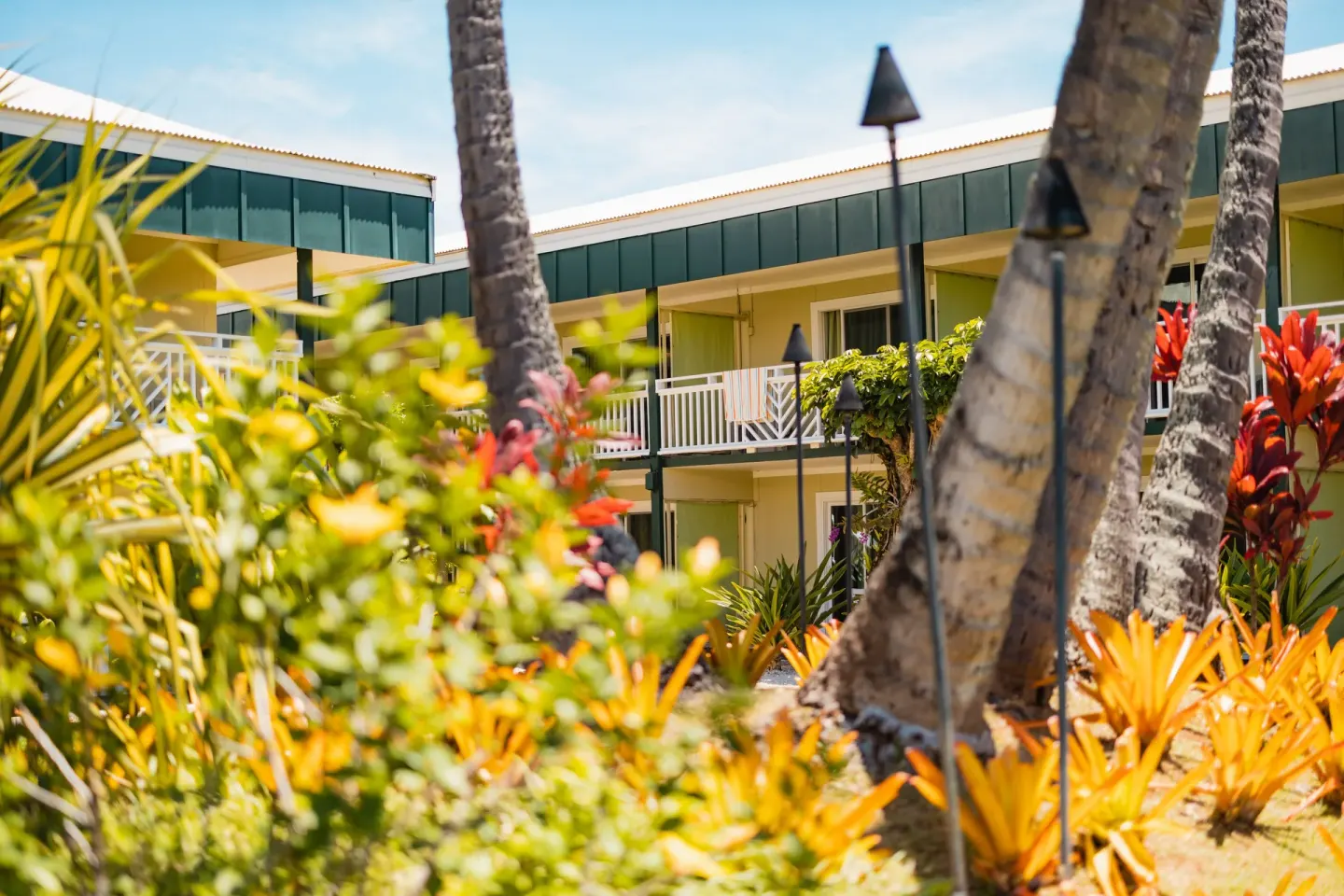 Tropical landscaping and guest room balconies at Kauai Shores Hotel.