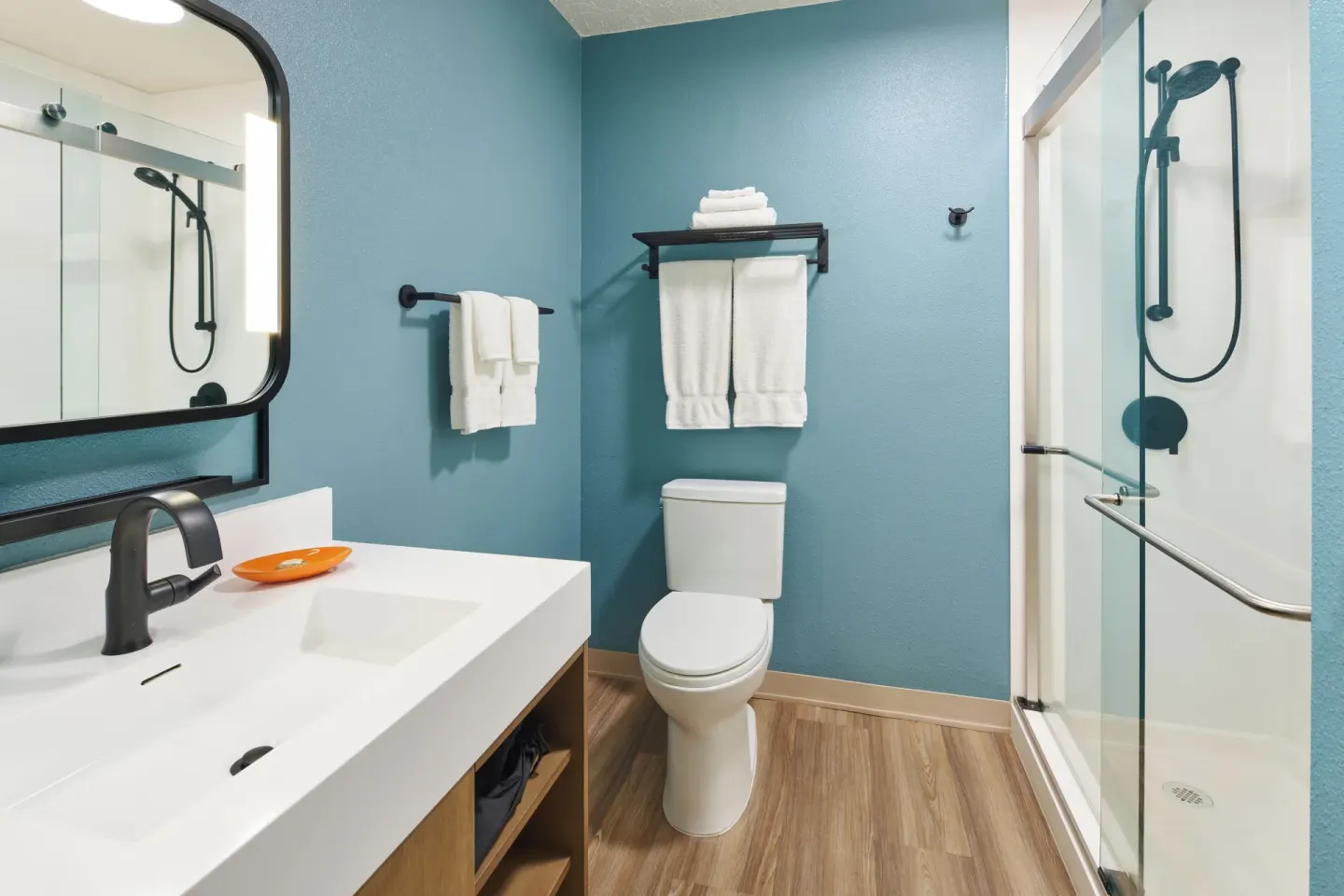 Garden View room bathroom with vanity, toilet, and glass shower at Kauai Shores Hotel.