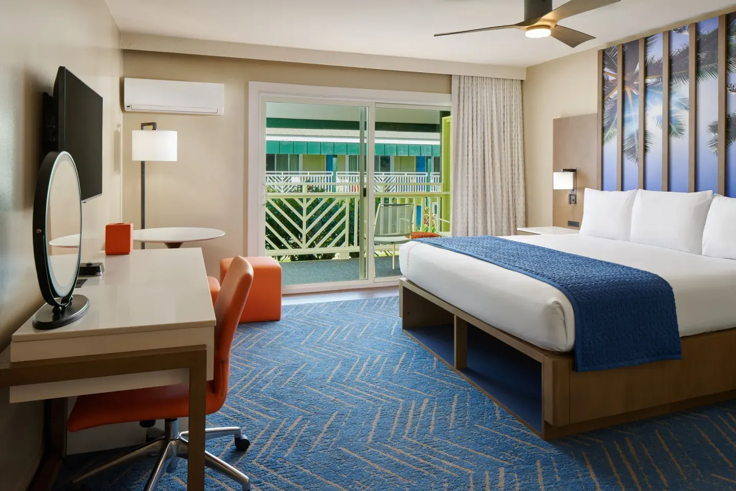 Garden View king room with bed, desk, and balcony doors at Kauai Shores Hotel.