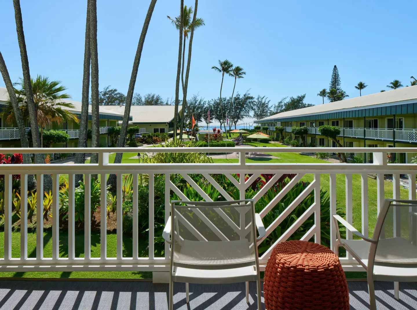 Balcony view from an Ocean View room at Kauai Shores Hotel with chairs and tropical landscaping.