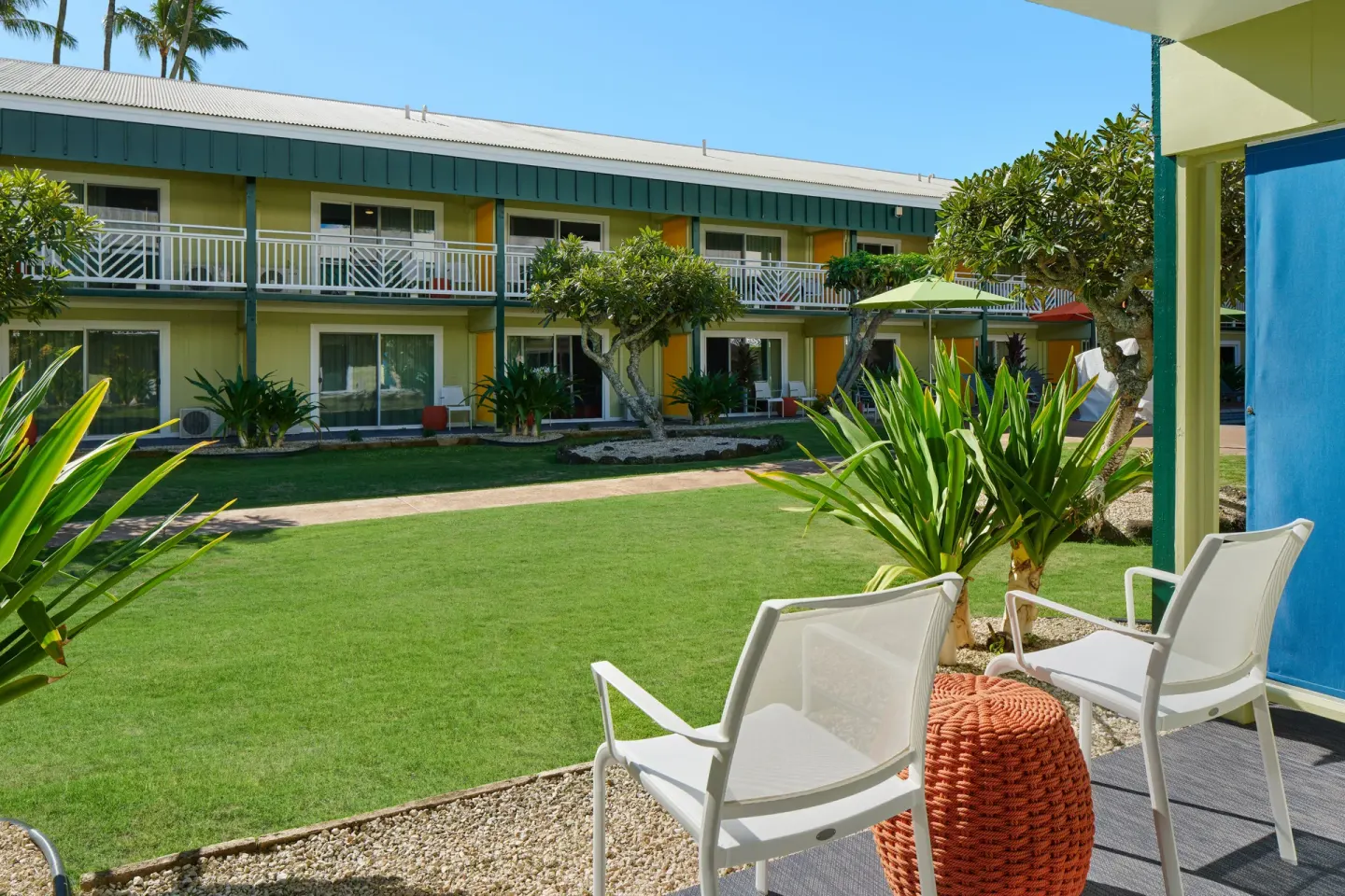 Studio patio seating facing a green courtyard at Kauai Shores Hotel.