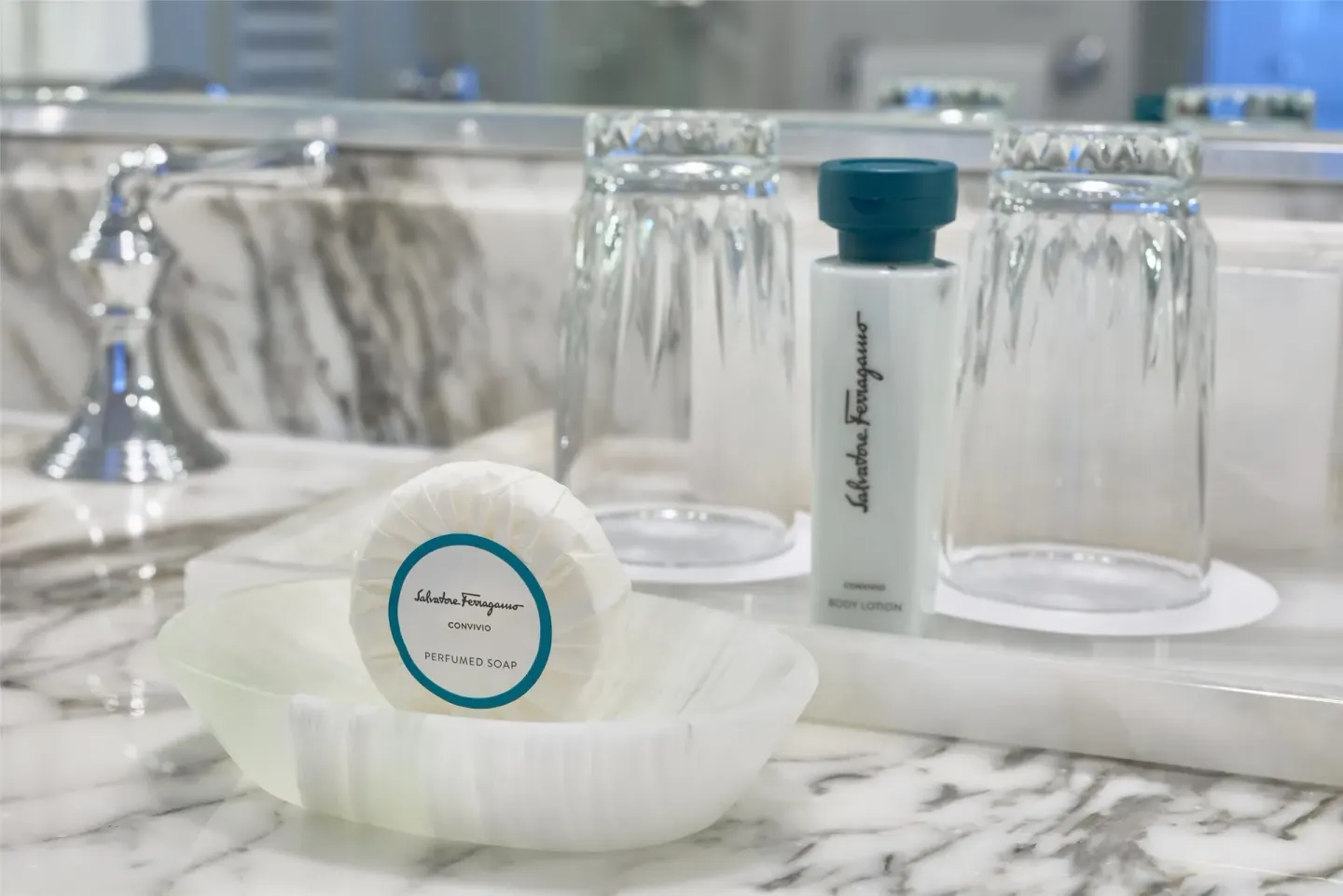 Bathroom vanity amenities with soap, lotion, and glasses at Kempinski Hotel Cancún.