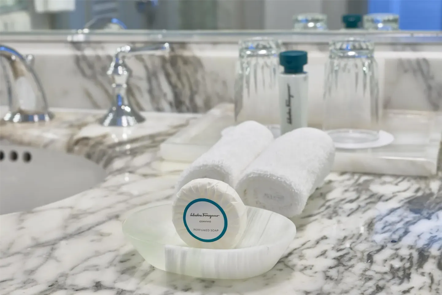 Rolled towels and bath amenities on a marble vanity at Kempinski Hotel Cancún.