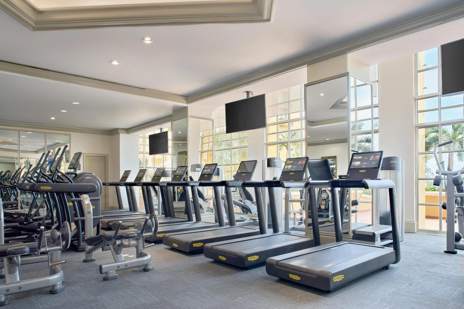 Treadmills line a mirrored fitness room at Kempinski Hotel Cancún.