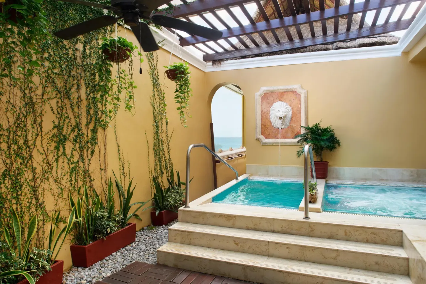 Garden terrace plunge pools with pergola and ocean glimpse at Kempinski Hotel Cancún.