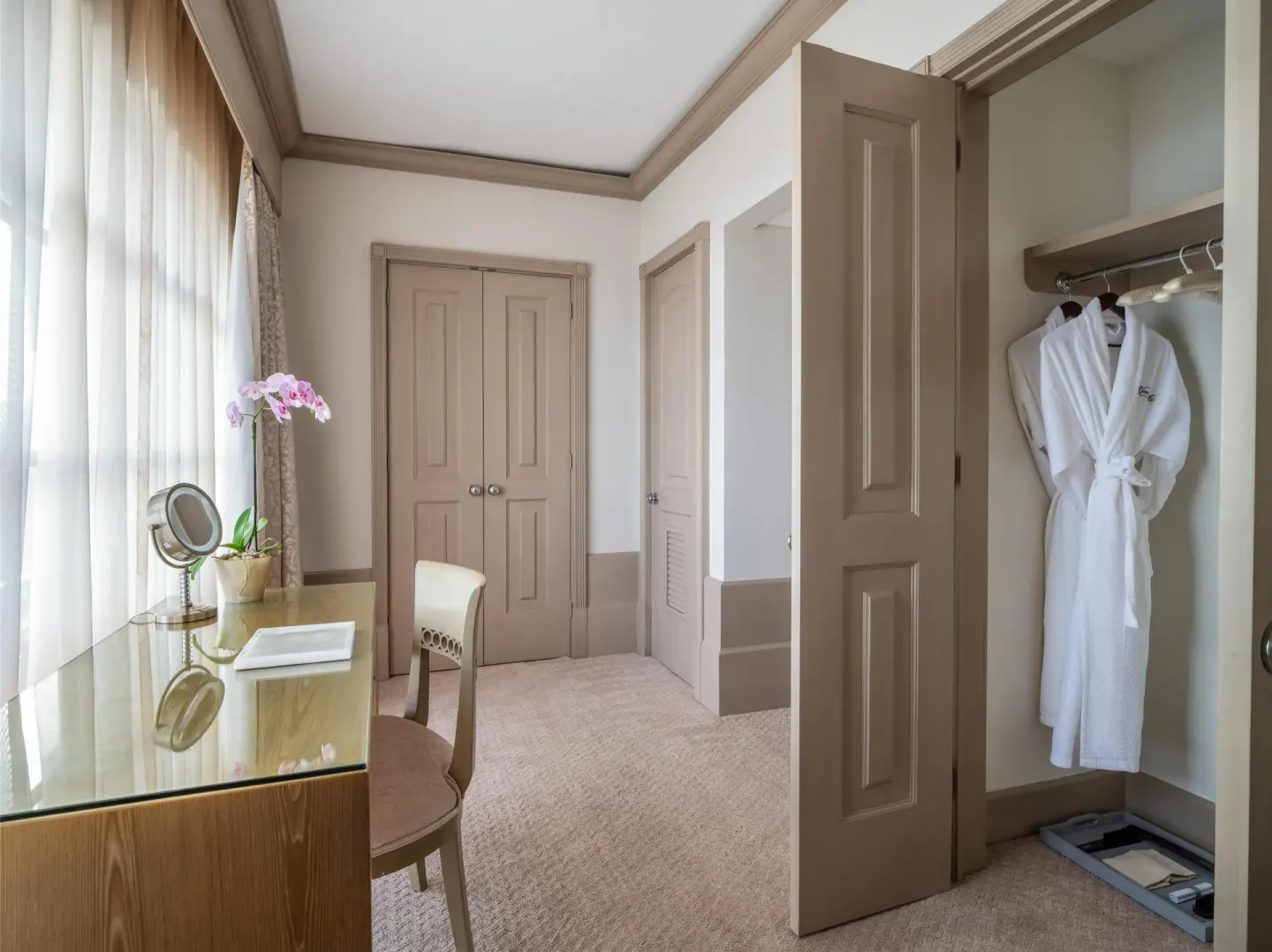 Guest room dressing area with vanity and robe closet at Kempinski Hotel Cancún.