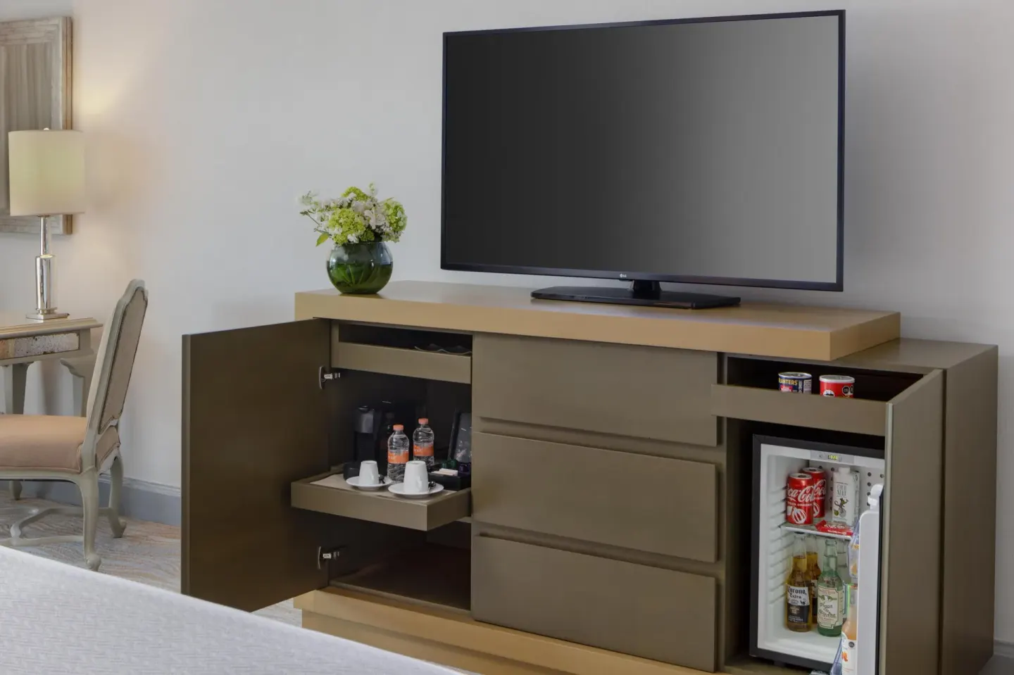 Guest room media cabinet with TV, minibar, and coffee service at Kempinski Hotel Cancún.