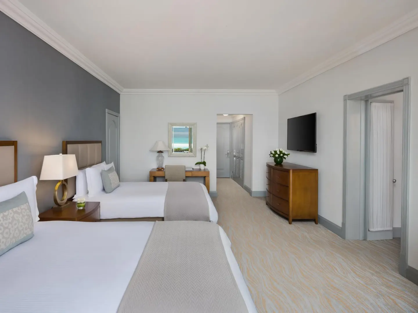 Guest room with two double beds, desk and television at Kempinski Hotel Cancún.