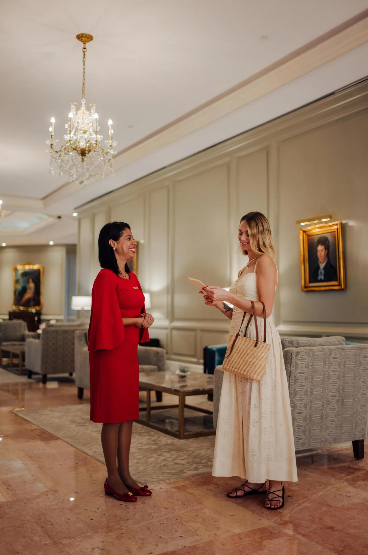 Guest and staff member talking in the lobby at Kempinski Hotel Cancún.