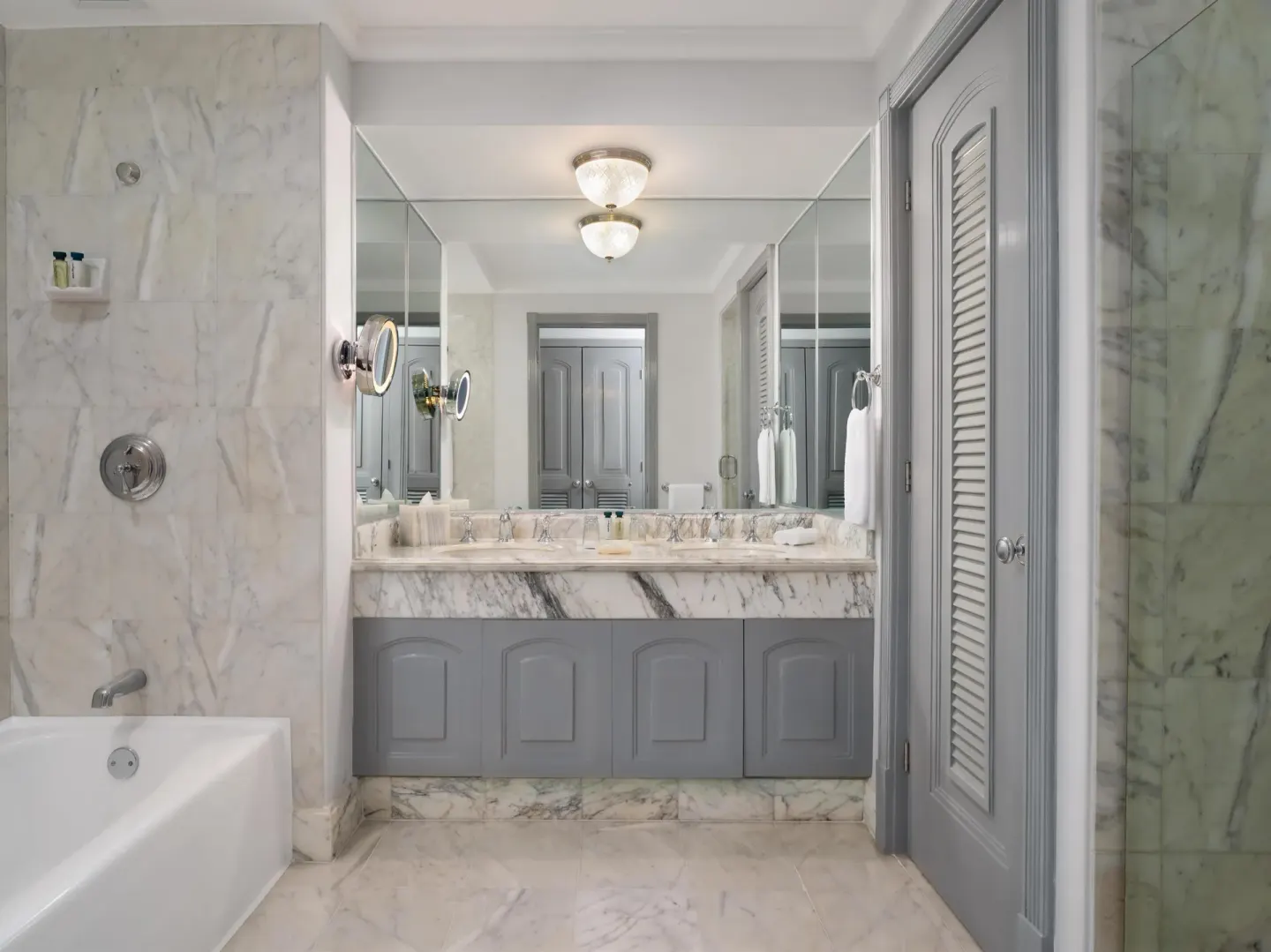 Marble bathroom with tub, vanity and glass shower at Kempinski Hotel Cancún.