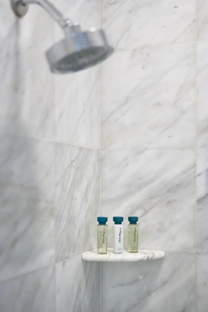 Marble shower with bath amenities on a ledge at Kempinski Hotel Cancún.