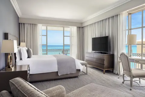 Ocean-view guest room with a king bed and balcony at Kempinski Hotel Cancún.